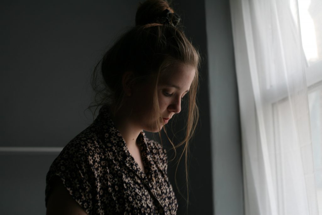 woman-standing-beside-window-curtain-1541212-1024x683